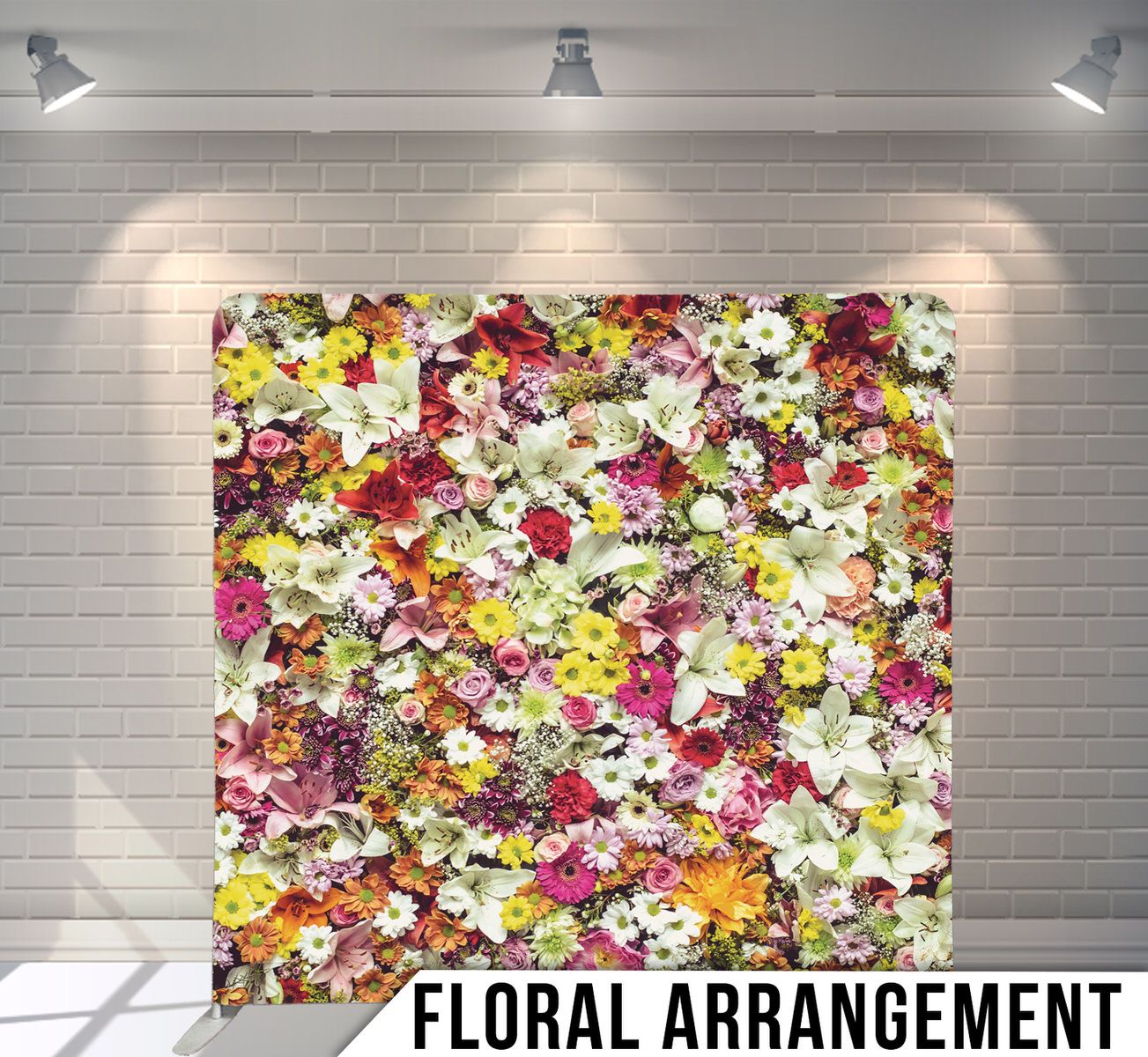 A vibrant backdrop of pink, white, and yellow flowers densely arranged in a repeating pattern against a white wall.