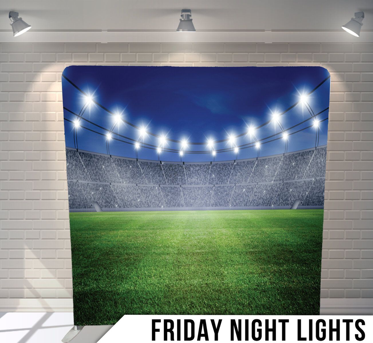 Stadium at night with bright floodlights illuminating an empty green soccer field.