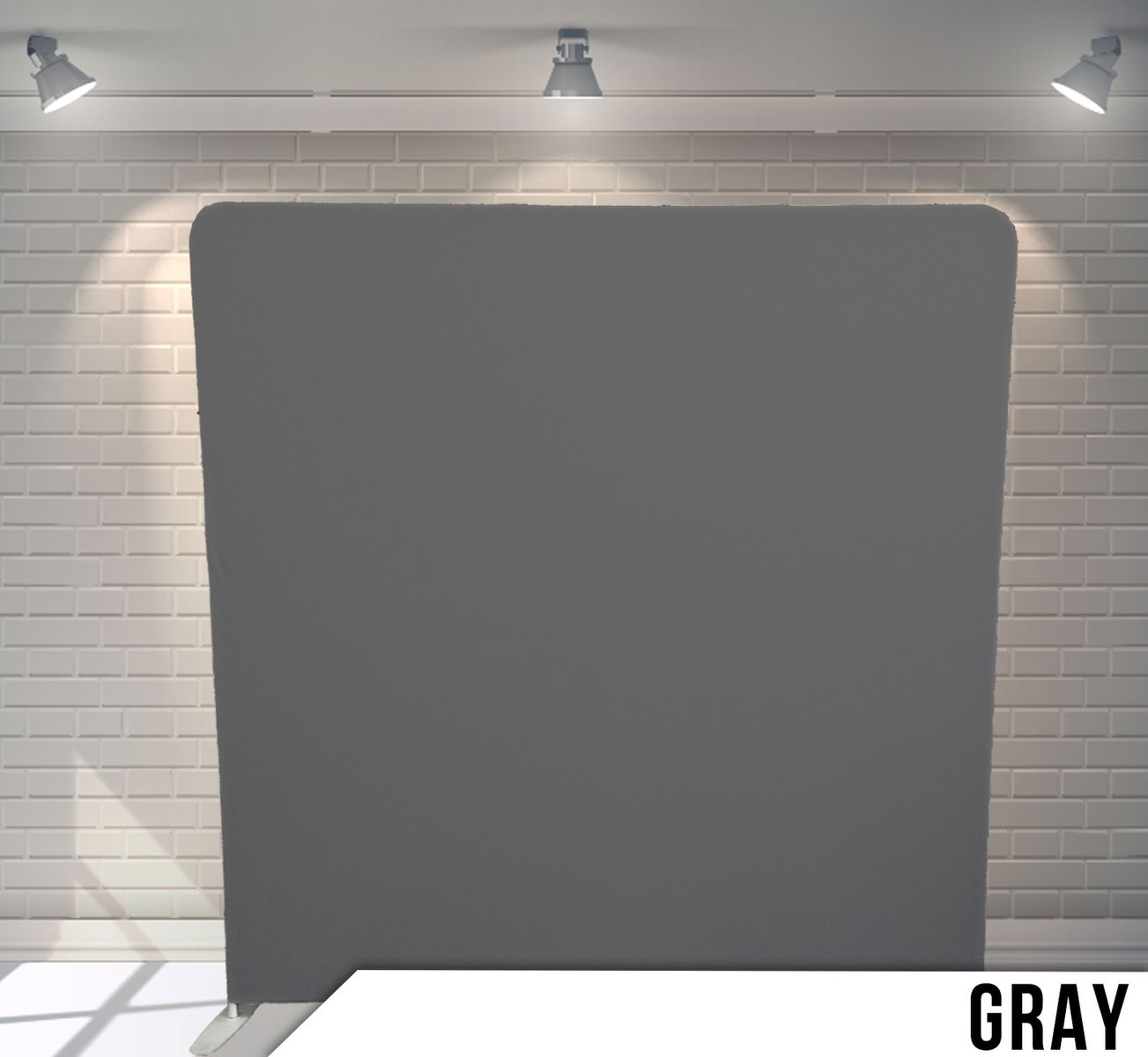 Plain gray photography backdrop displayed against white brick wall with studio lighting.