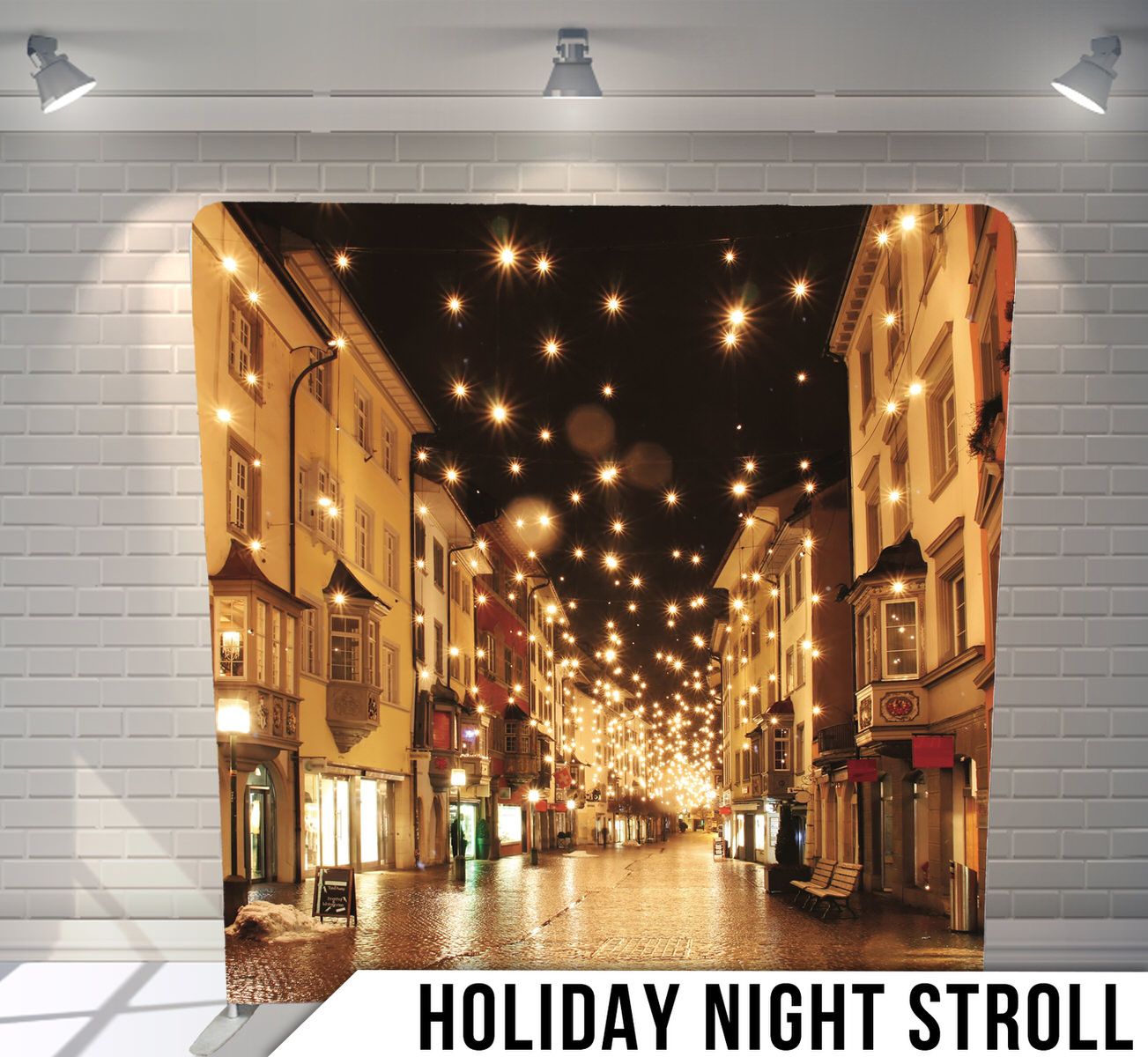 Charming European street at night illuminated by warm glowing string lights during holiday season.