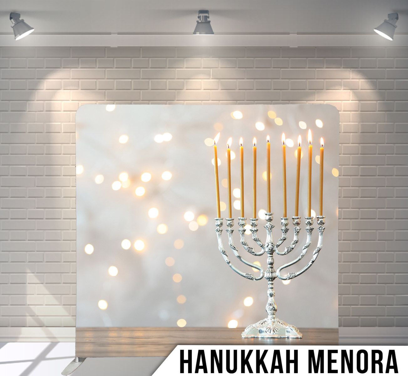 Lit silver Hanukkah menorah with glowing candles against bokeh light background.