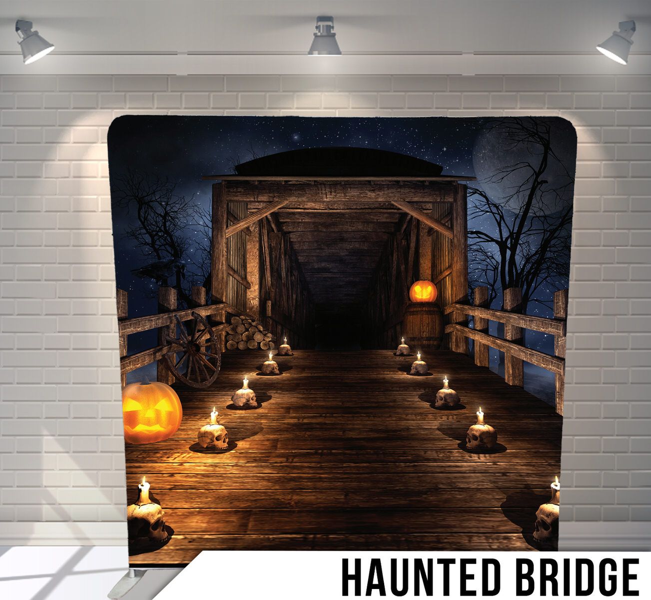 A spooky wooden covered bridge lit by candlelight and pumpkins on a dark night with bare trees.