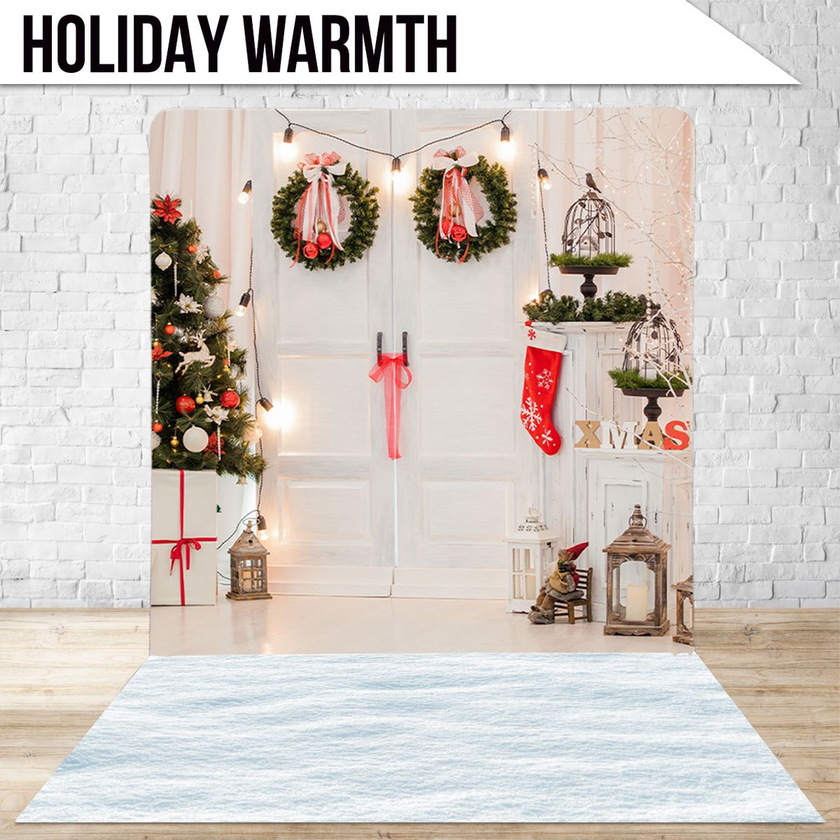 Cozy holiday scene with wreaths, stockings, lanterns and Christmas tree against white brick wall.