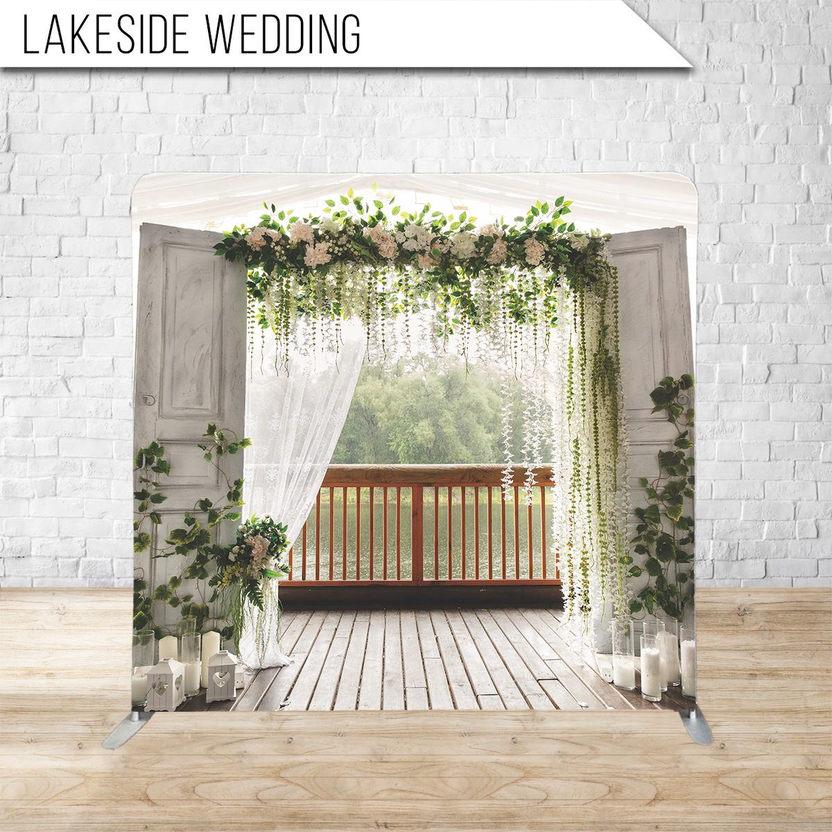 Elegant wedding arch decorated with white curtains and cascading greenery overlooking lakeside view.