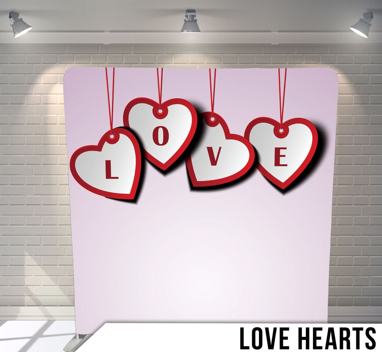 Hanging red heart ornaments spelling LOVE on light pink background.