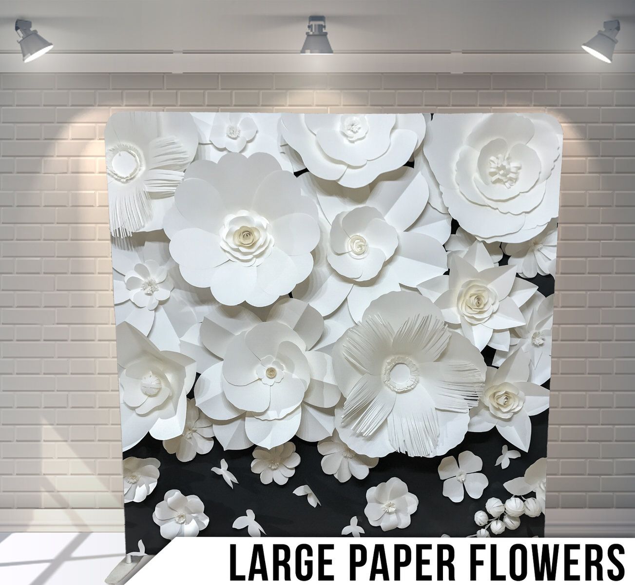 3D white paper flowers wall art installation against black background.