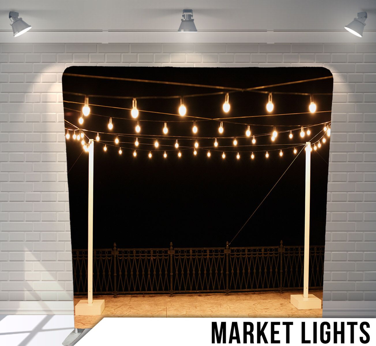 String of warm glowing market lights hanging against dark night sky.