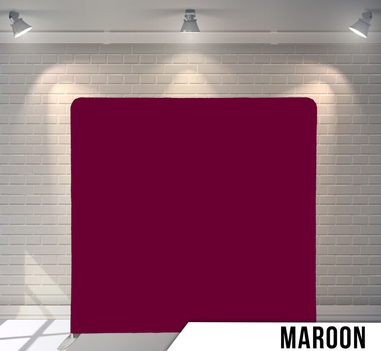 Solid maroon colored backdrop with spotlights shining from above.