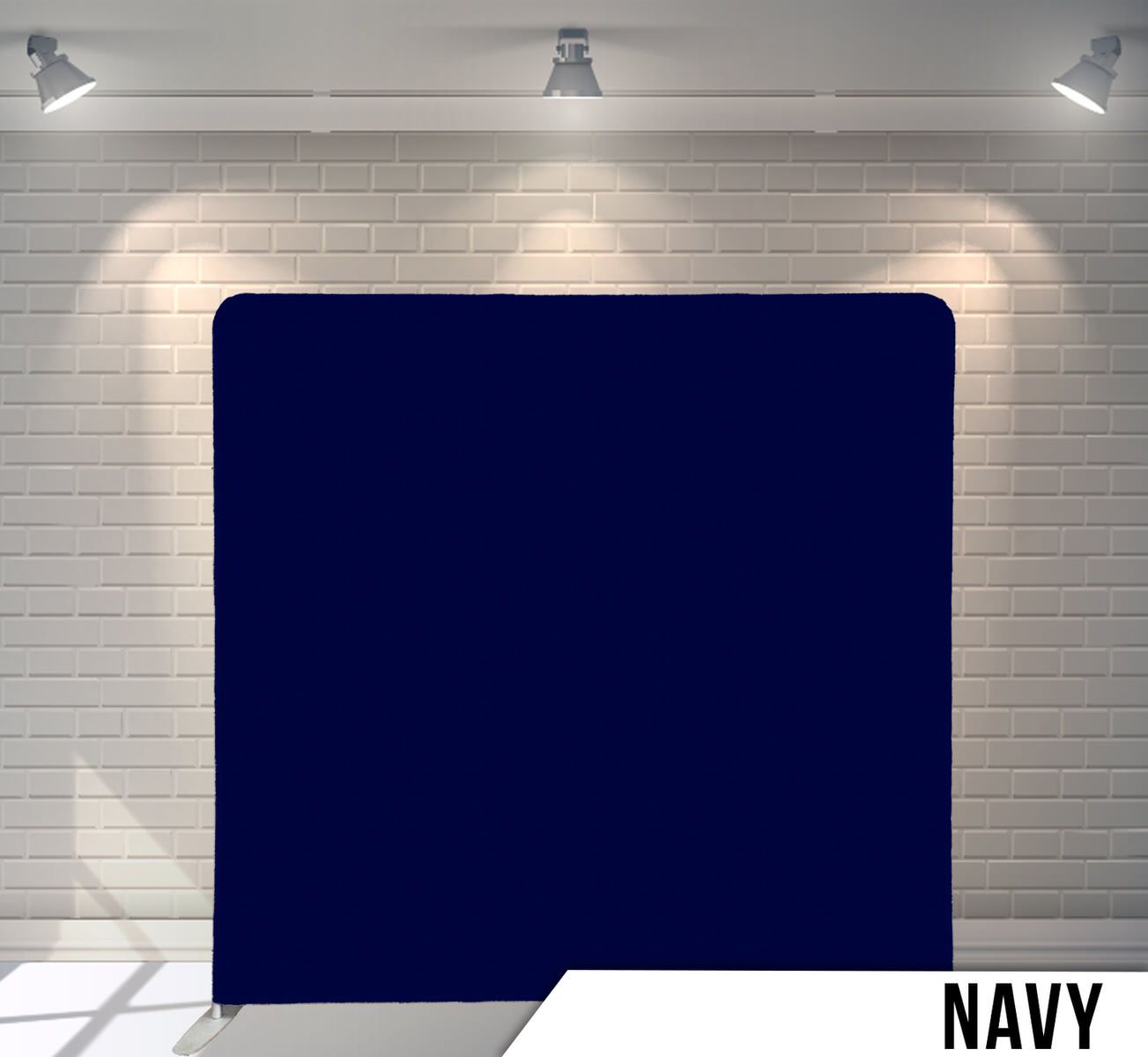 Solid navy blue backdrop against white brick wall with studio lighting.