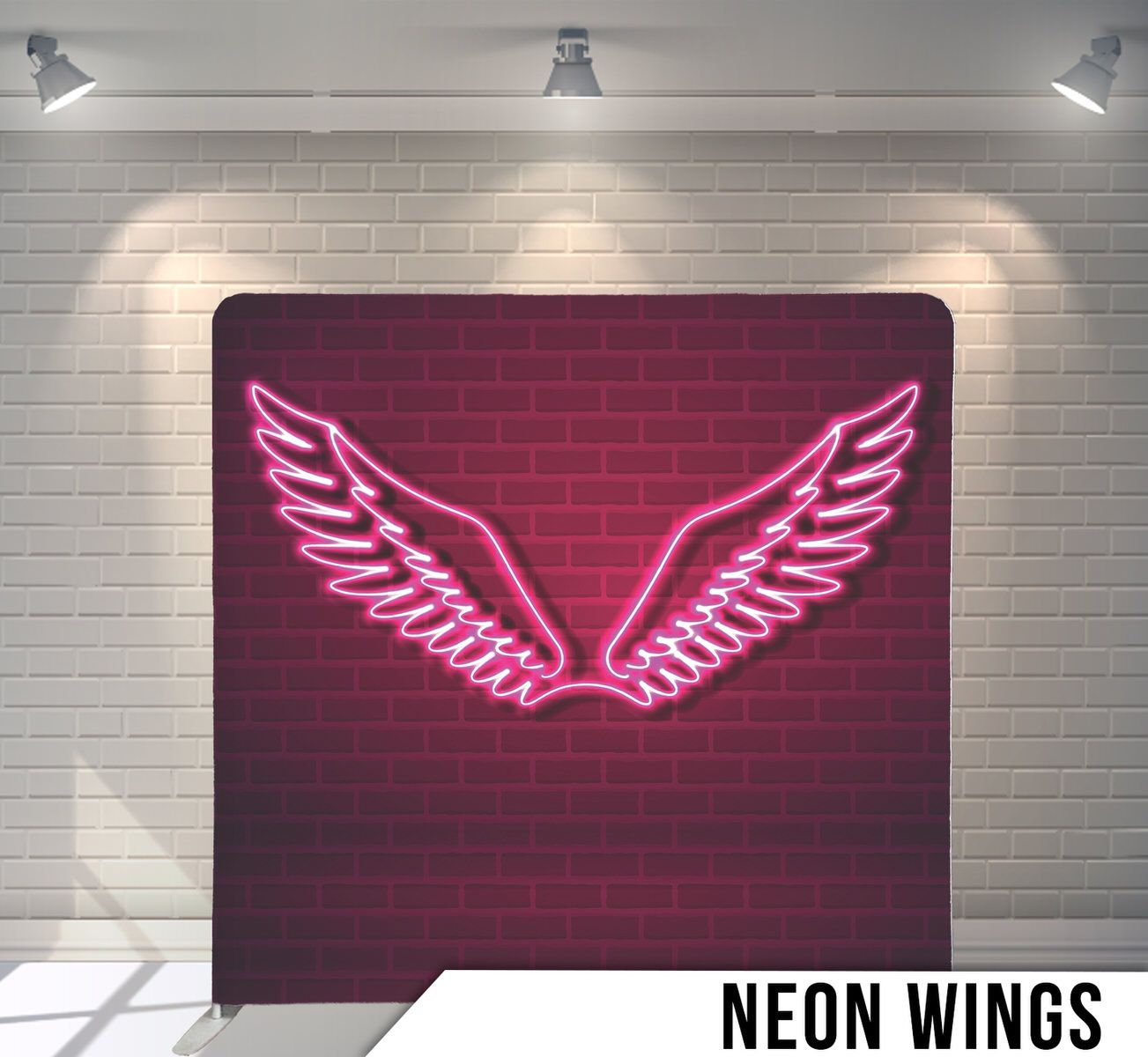 Glowing pink neon angel wings design against a dark red brick wall background.