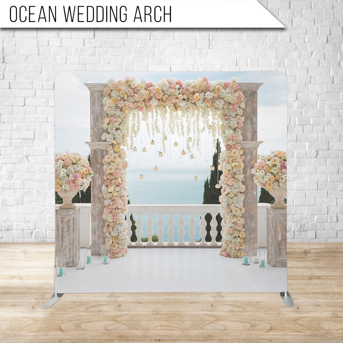 Elegant wedding arch decorated with pink and peach flowers overlooking ocean view.