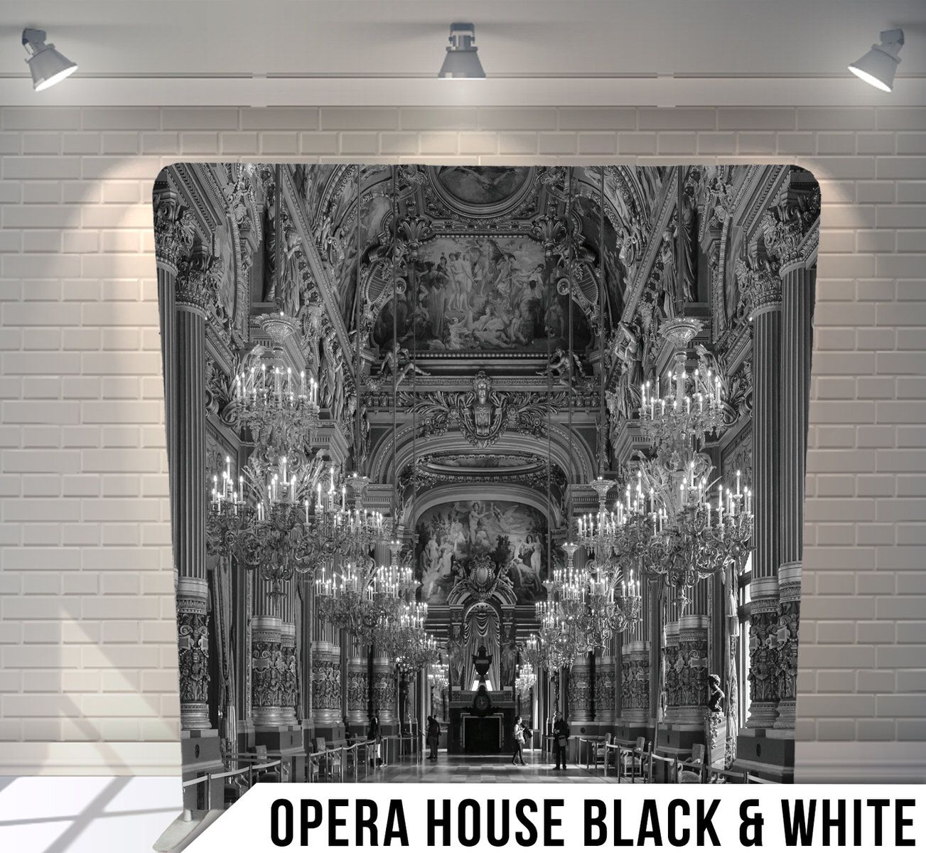 Black and white photo of grand opera house interior with ornate chandeliers and architectural details.