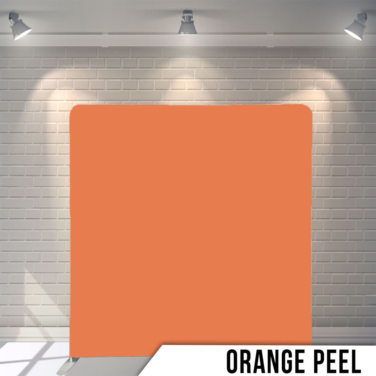 Light orange peel colored backdrop panel against white brick wall with overhead lighting.