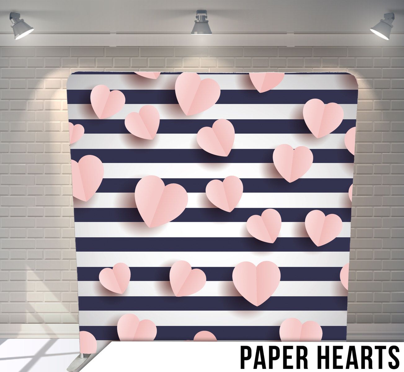 Pink paper hearts scattered across navy blue and white striped background.