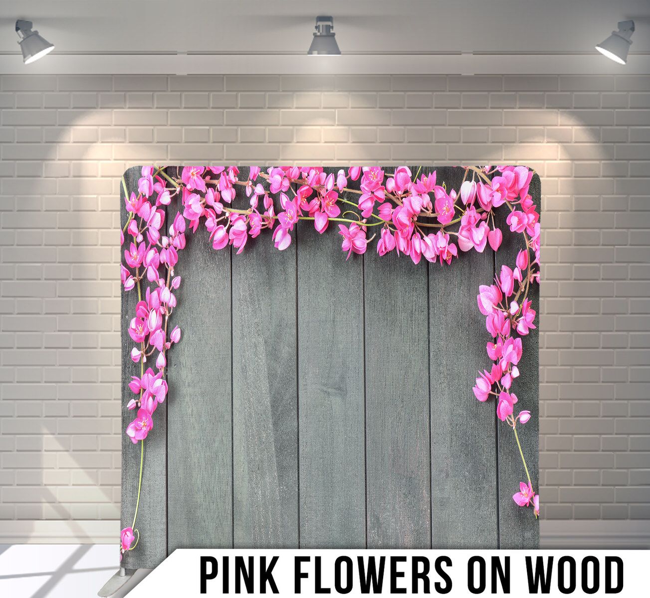 Pink cherry blossoms arranged on grey wooden planks creating an elegant archway design.