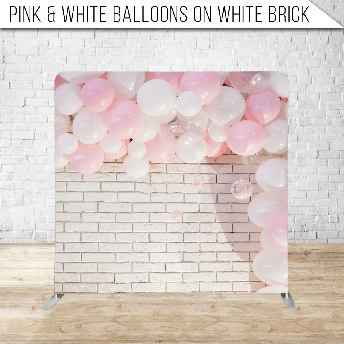 Pink and white balloons decoratively arranged along white brick wall for party backdrop.