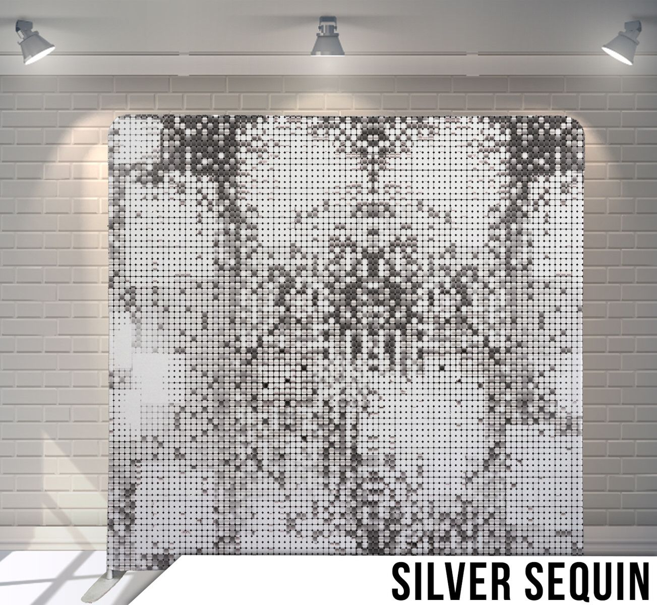 Silver sequined backdrop with mosaic pattern illuminated by spotlights against white brick wall.