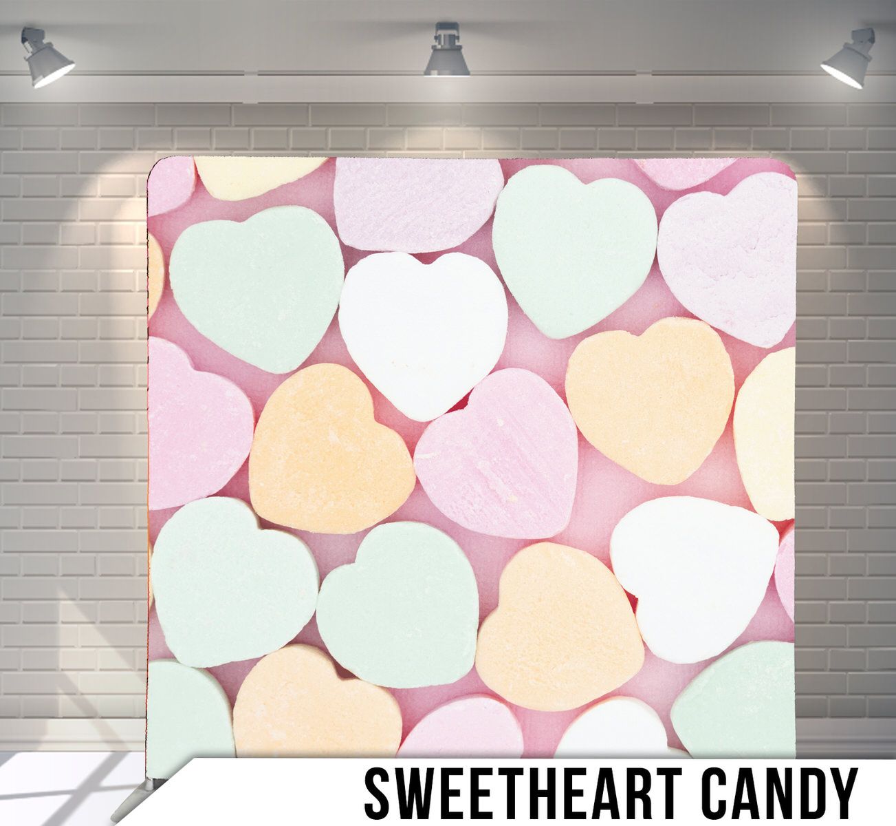 Pastel conversation hearts candy arranged in heart shapes on pink background.