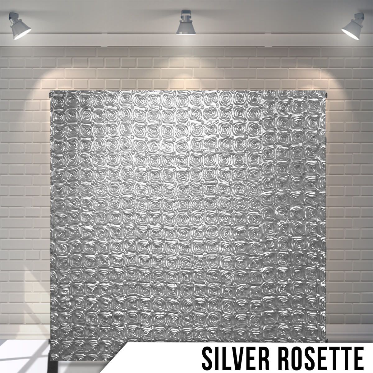 Textured silver rosette pattern backdrop with circular geometric design under spotlights.