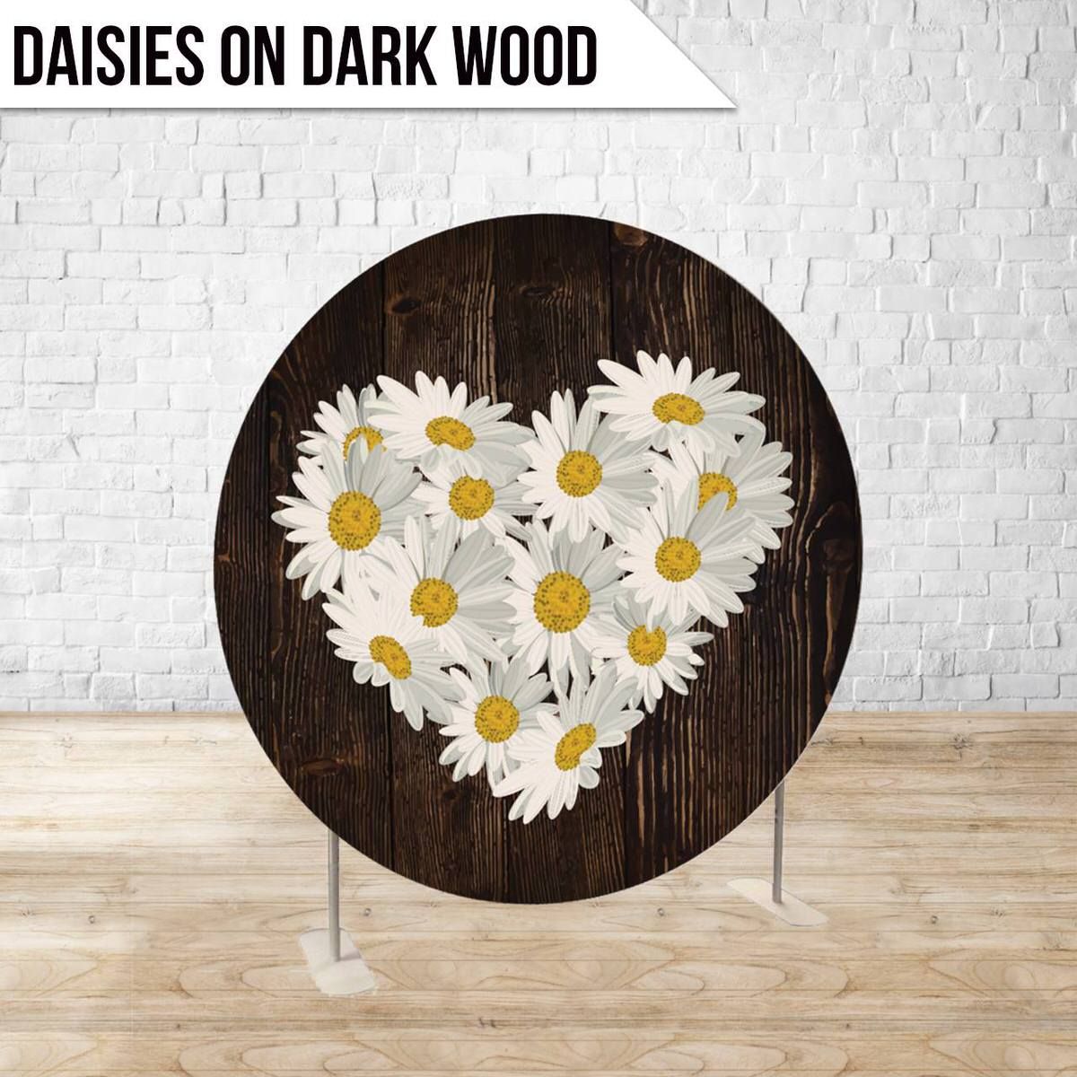 White daisies arranged in heart shape on dark wooden circular surface.