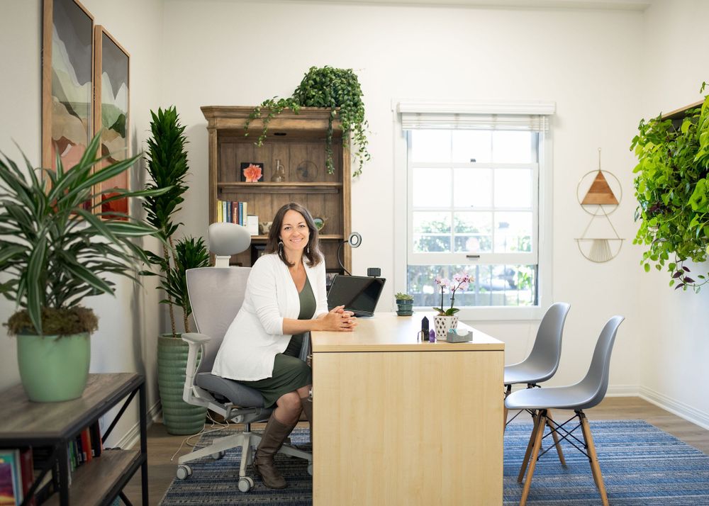pregnant doctor looking smiling at the camera while sitting at her desk in her office