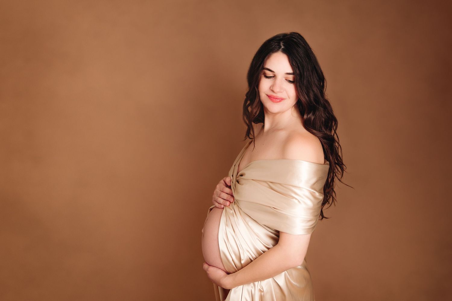 kc missouri maternity photography session of woman draped in gold fabric