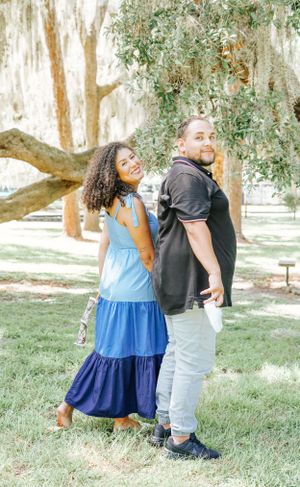 A couple dancing and celebrating together under moss-covered trees.