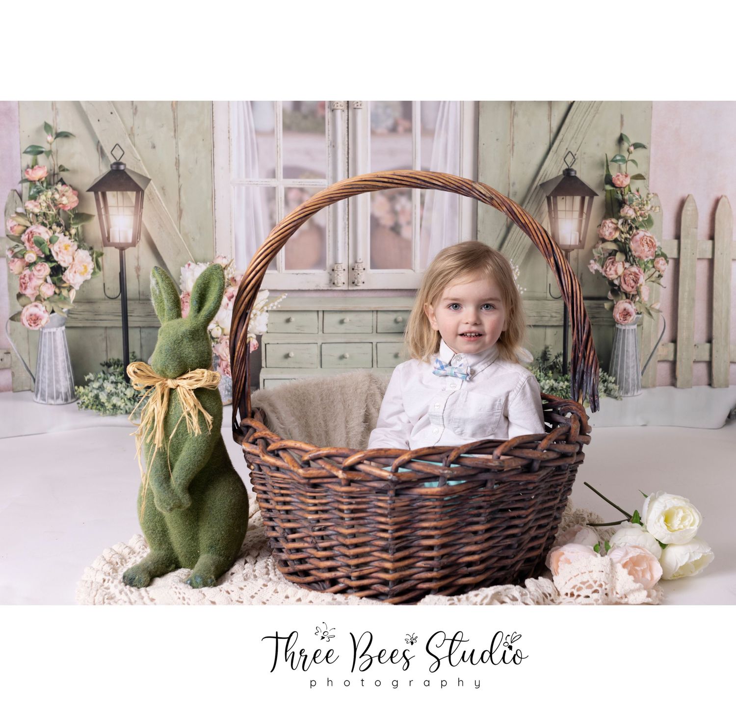 Sweet spring photo setup with large woven basket, green bunny plush, and floral decorations.