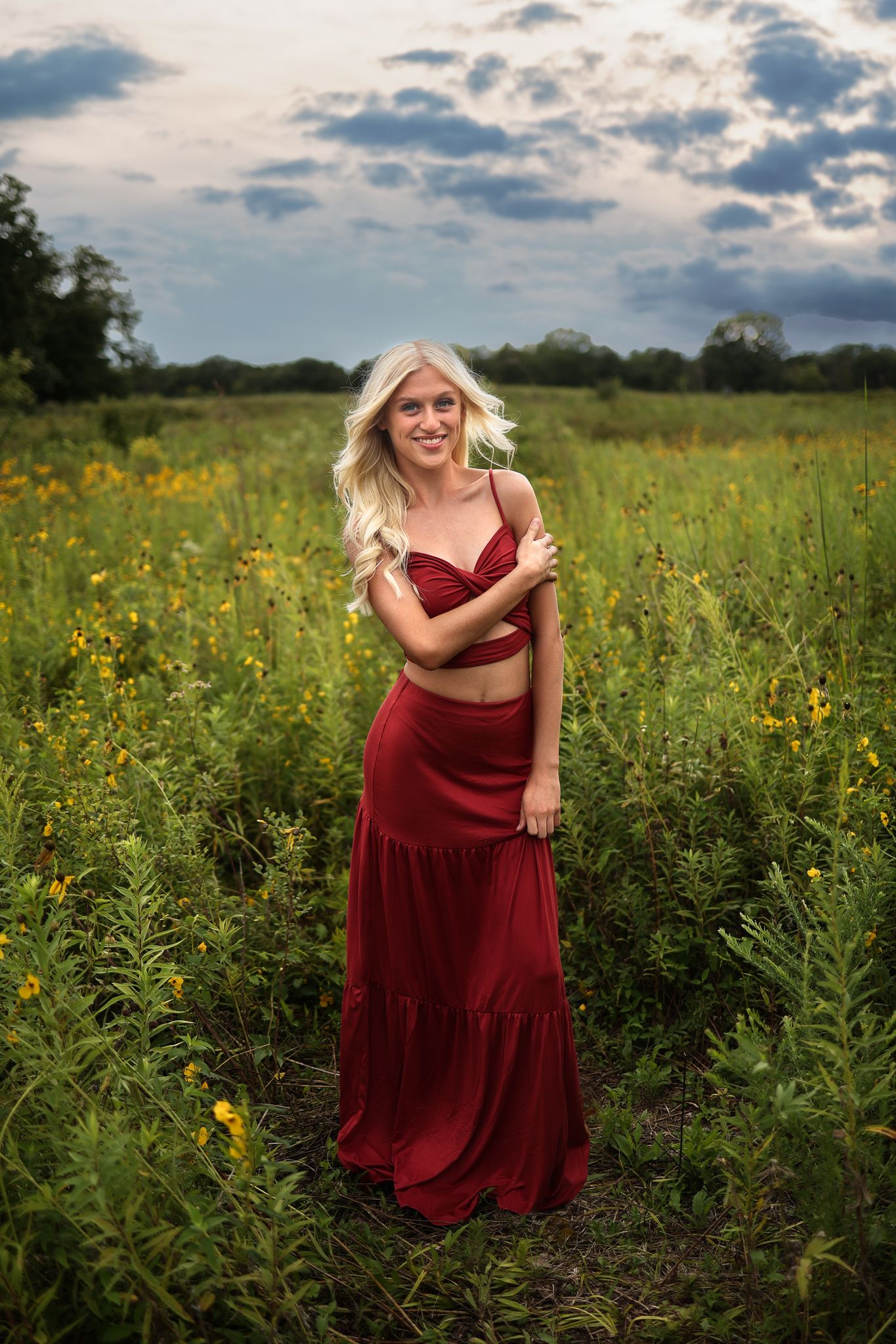 A romantic sunset portrait in a wildflower meadow with a flowing red dress.