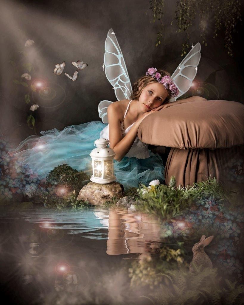 Ethereal fairy portrait with blue dress and lantern reflecting on mystical waters.