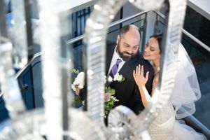 Bride and groom share a tender moment framed by crystal chandelier details on their wedding day.