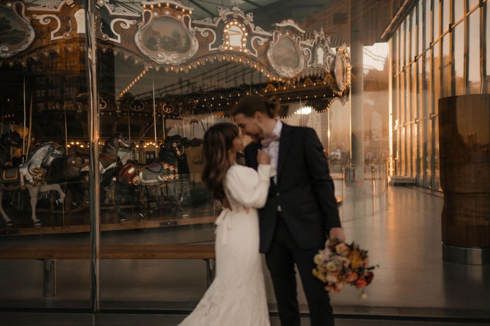 Tender wedding portrait with a vintage carousel backdrop and romantic lighting.