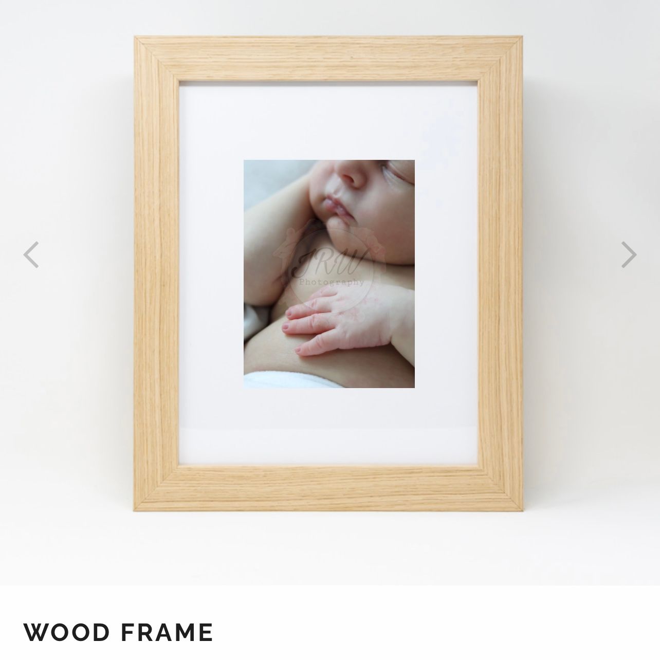 Baby detail photographs presented in natural wood frames against a white wall.