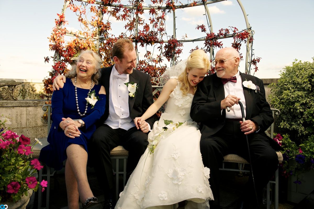 Wedding couple with her parents laughing in a bower