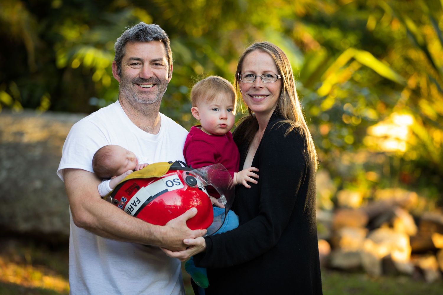 fireman dad with mum and toddler boy and baby girl in helmet