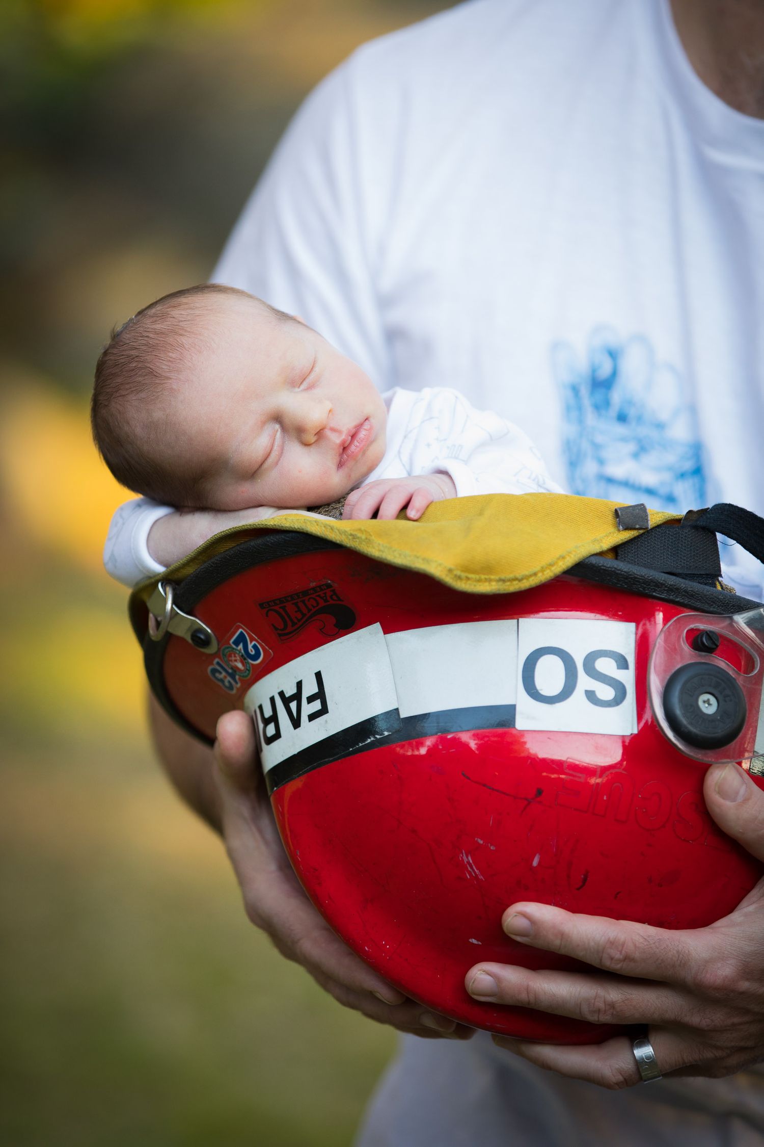 newborn baby in a firemans helmet