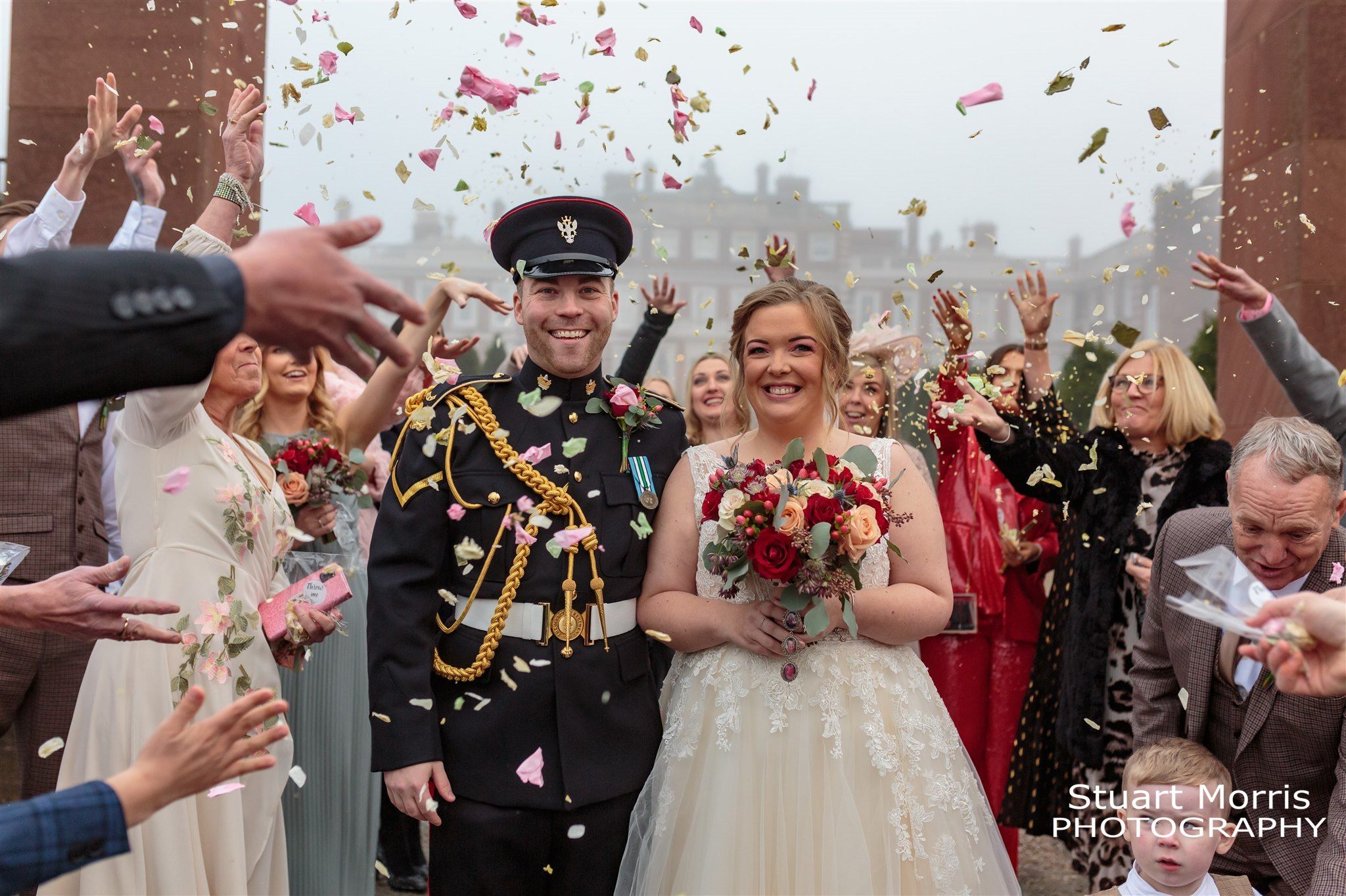 Bride and groom showered in confetti in the grounds of Knowsley hall. Liverpool wedding photographs.