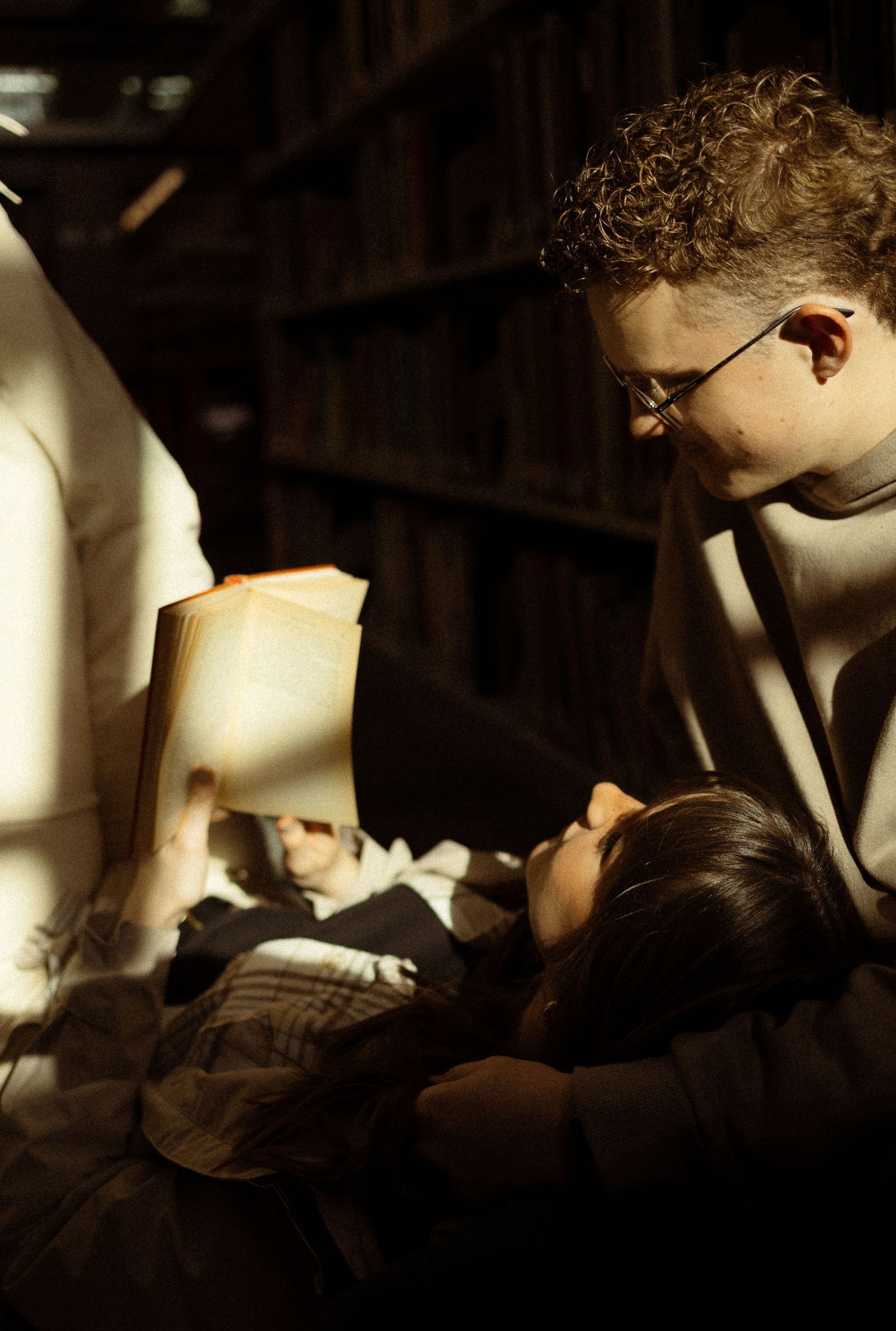 A couple in a library with books snuggling together