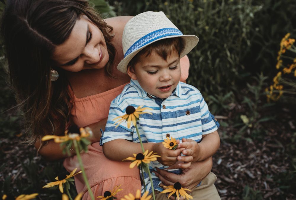 A tender moment in a garden as they admire blooming yellow flowers on a sunny day.