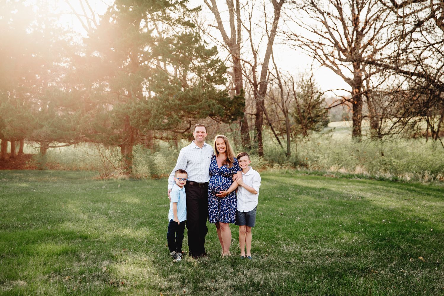 mom, dad and two boys pose for family maternity photoshoot