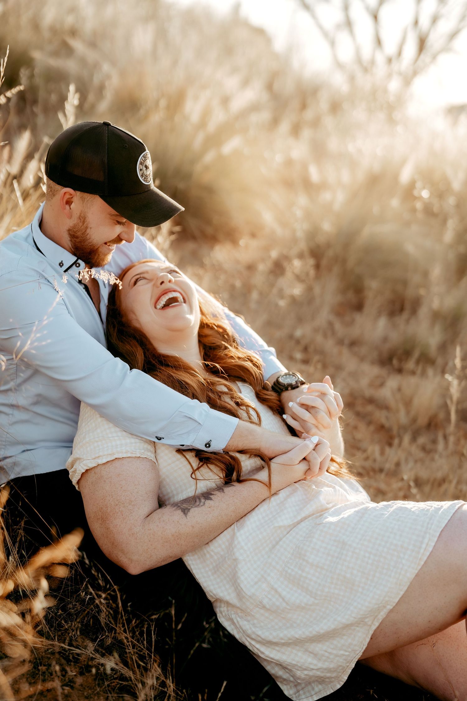 Couple sharing an intimate moment during golden hour in a natural outdoor setting.
