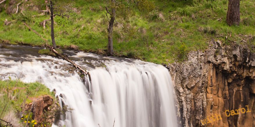 Close-up view of cascading waterfall dropping over rocky cliff face.