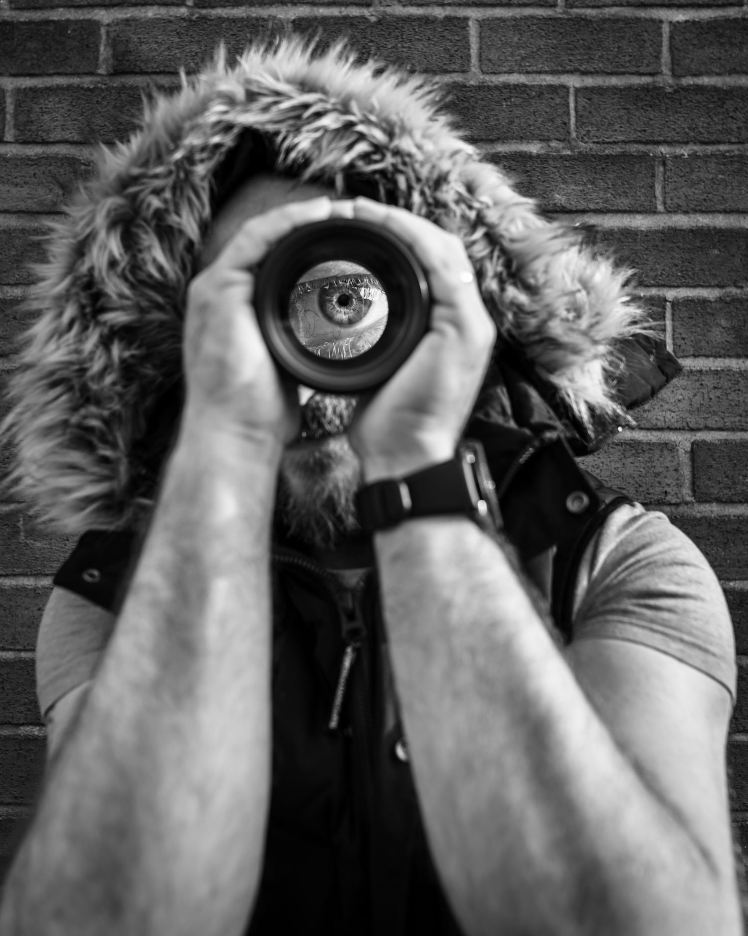Black and white photo of photographer looking through lens.