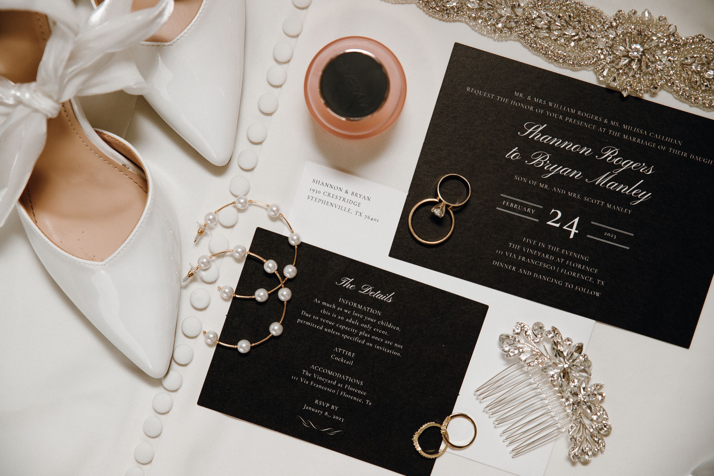 Wedding day flat lay featuring elegant shoes, invitations, perfume, jewelry, wedding rings, and accessories, all beautifully arranged.