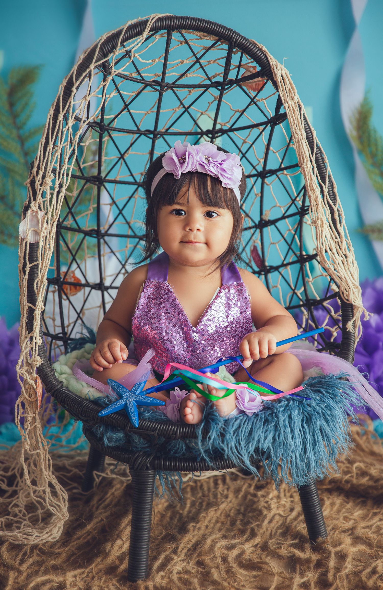 baby girl in mermaid clothing holding wand