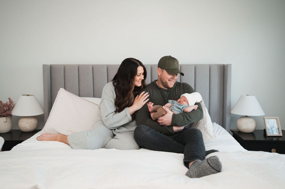 A family enjoys time with their newborn as theyre photographed by a talented Lehi family photographer.