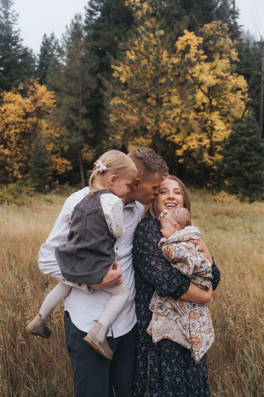 A family laughs together during their annual fall family photoshoot for their Christmas card photos.