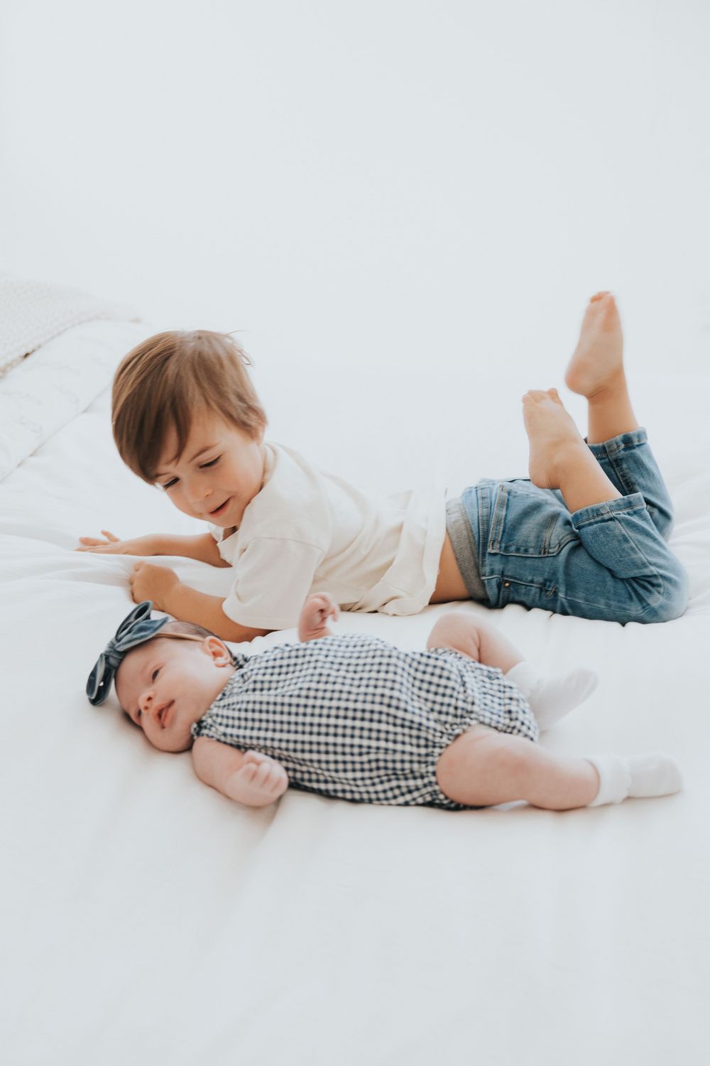 A brother smiles at his newborn sister during a family photoshoot near American Fork, Utah.