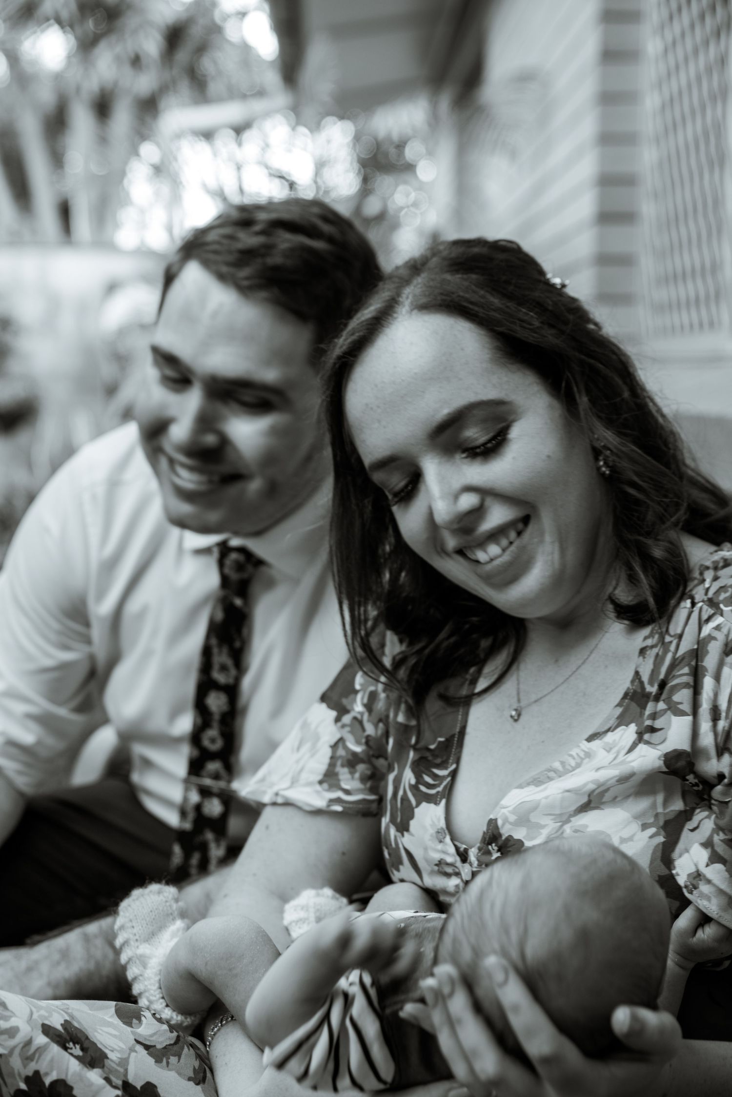 A joyful candid moment shared between a couple with a small infant.