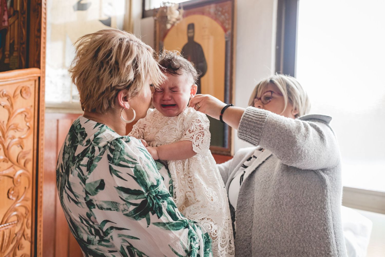 A tender moment during a baby's christening ceremony in a church setting.